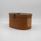 Vista laterale cappelliera antica con coperchio in cuoio