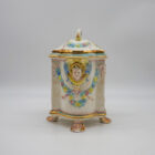 Vaso Capodimonte in porcellana con coperchio, decorazione a rilievo con putti e testa femminile